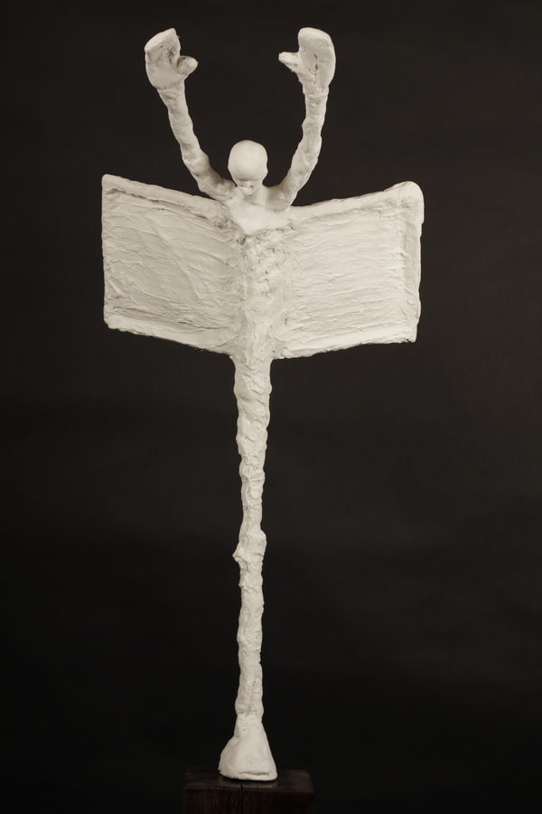 Closer photograph of the pale raised-arm figure, showing texture across the broad form.
