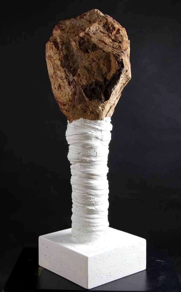 Reverse view of the stone with a deep natural cavity, supported by the white wrapped column and square pale base.